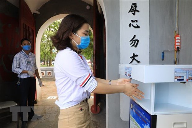 Du khách rửa tay sát khuẩn trước khi vào thăm quan Di tích Đền Ngọc Sơn-Tháp Bút.