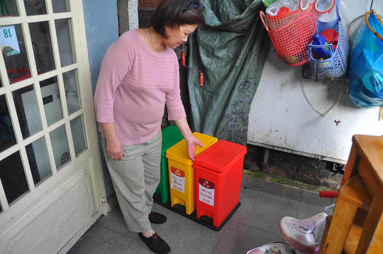 Bà Phan Thị Lan với thùng rác 3 màu được cấp để phân loại rác thải sinh hoạt