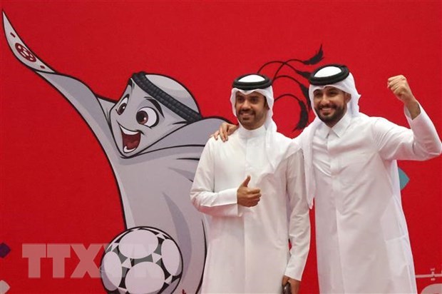 Người dân chụp ảnh bên hình ảnh linh vật World Cup Qatar 2022 ở Doha. (Ảnh: AFP/TTXVN)