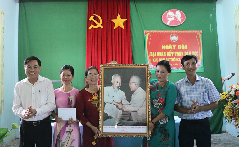 Đồng chí Võ Ngọc Hiệp - Ủy viên Ban Thường vụ Tỉnh ủy, Chủ tịch Ủy ban MTTQ tỉnh trao tặng quà cùng với bức ảnh Bác Hồ và Bác Tôn cho cán bộ và Nhân dân Thôn 3