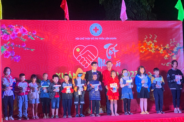 Lãnh đạo Hội Chữ thập đỏ tỉnh và lãnh đạo thị trấn Liên Nghĩa trao quà cho các em học sinh.