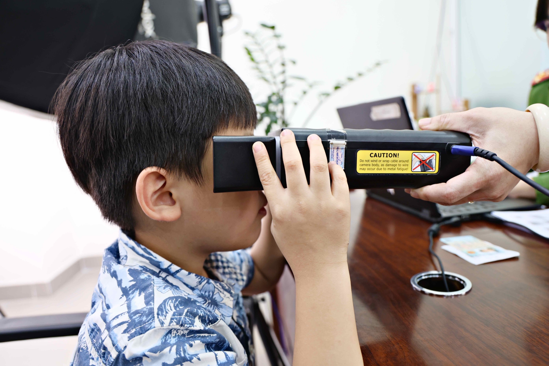 Một công dân nhí được thực hiện các thủ tục đo mống mắt, chụp ảnh thẻ,...để làm căn cước  công dân gắn chíp điện tử