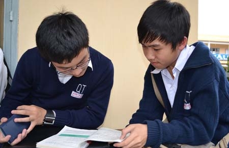 Thí sinh ôn lại bài chuẩn bị vào phòng thi. Ảnh: Văn Báu