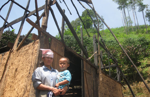 Chị Vũ Thị Hường và con nhỏ trước căn nhà bị cháy hoàn toàn