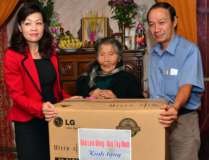 Đại diện lãnh đão Báo Tây Ninh (bìa phải)  và lãnh đạo Báo Lâm Đồng (bìa trái) tặng quà cho Mẹ Việt Nam Anh hùng Ngô Thị Quanh.