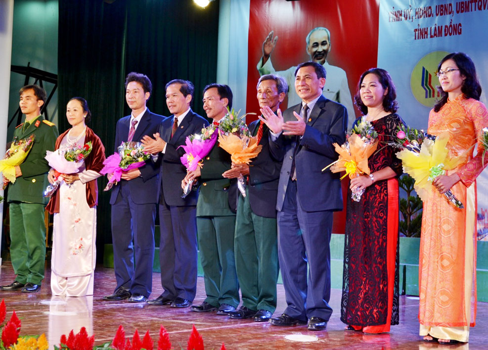 Đ/c Nguyễn Xuân Tiến (thứ tư trái qua) và đ/c Phạm Kim Khang (thứ ba phải qua)  tặng hoa chúc mừng cho 65 gương mặt tiêu biểu trong phong trào thi đua yêu nước của Lâm Đồng giai đoạn 2008 - 2013. Ảnh: Văn Báu