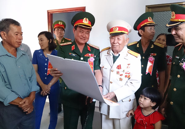 Trung tướng Trần Đơn - Uỷ viên Trung ương Đảng, Uỷ viên Quân uỷ Trung ương, Tư lệnh Quân khu 7, trao hoa chúc mừng của Đại tướng Phùng Quang Thanh, Bộ trưởng Bộ Quốc phòng, cho cụ Tô Đình Cắm