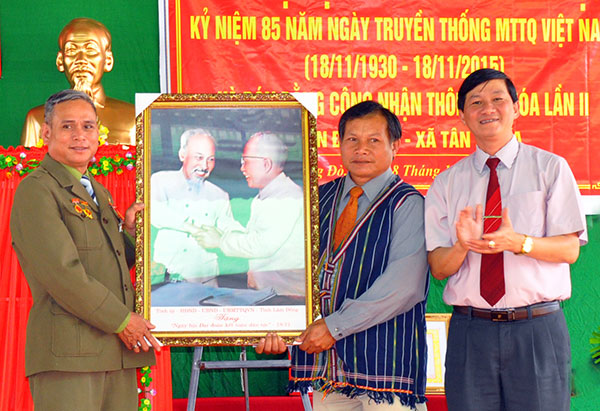 Đồng chí Trần Đức Quận tặng thôn Đồng Đò bức ảnh Bác Hồ với Bác Tôn - Ảnh: BÙI TRƯỞNG