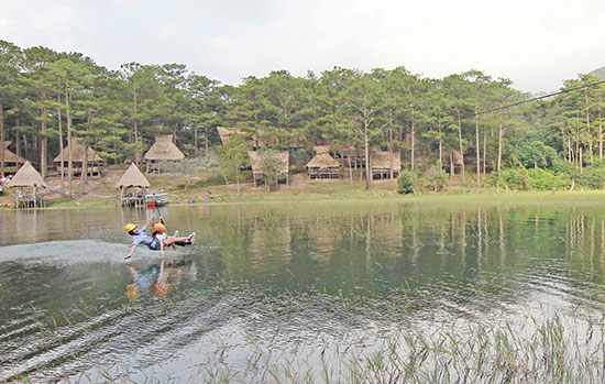 Du khách nữ thử trải nghiệm trò đu dây Zipline trên hồ Tuyền Lâm