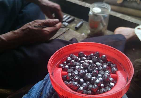Trước khi đi săn, Ha Hai mua hai thanh chì tại trung tâm huyện về cắt nhỏ, ép thành những viên bi tròn như thế này để làm đạn cho khẩu súng kíp tự chế