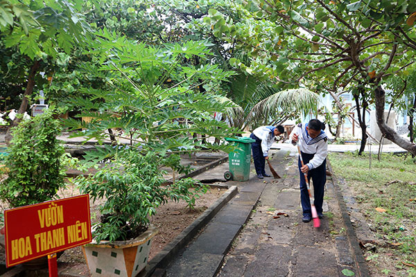 Nguyễn Hoàng Tây và Châu Minh Phong với nhiệm vụ đầu tiên của đời lính đảo - dọn dẹp Vườn hoa thanh niên. Ảnh: D.Thương