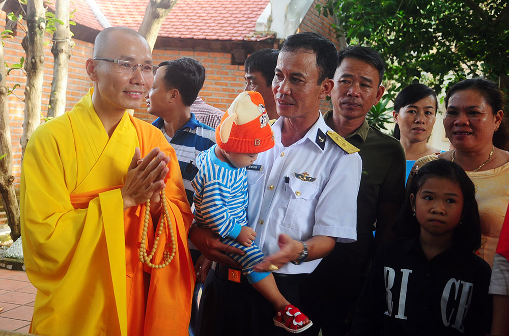 Hòa thượng Thích Tâm Tánh trụ trì chùa Trường Sa, Trung tá Đỗ Thế Tuyến - Đảo trưởng đảo Trường Sa và bé Hải Thùy trong ngày đầu năm mới. Ảnh: T.Linh