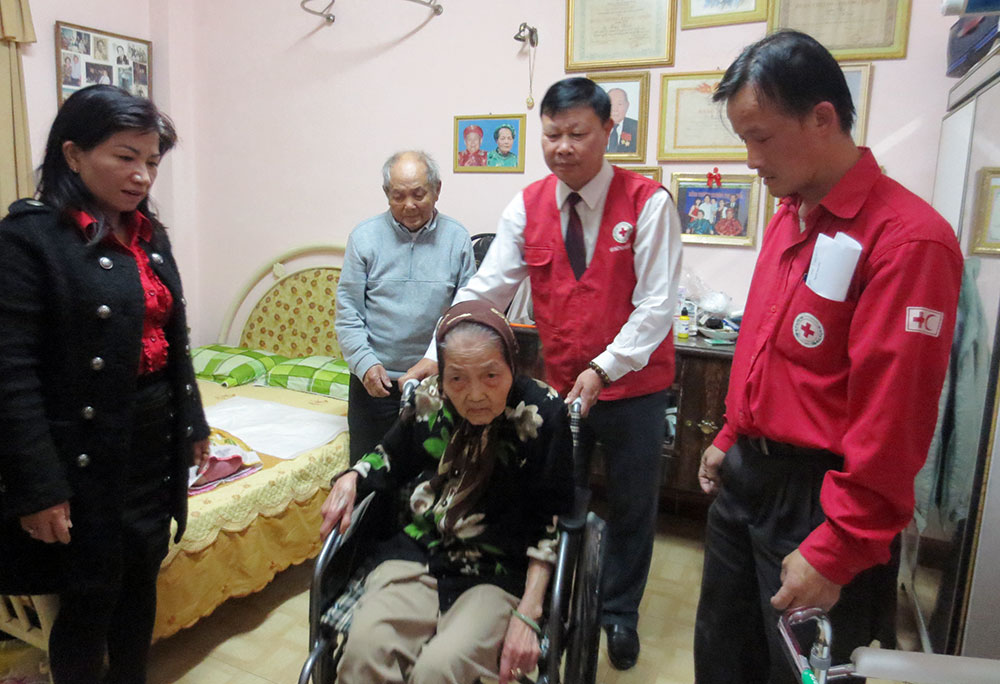 Lãnh đạo Hội Chữ thập đỏ tỉnh Lâm Đồng trao xe lăn cho bệnh nhân bị bệnh bại liệt tại thành phố Đà Lạt. Ảnh: V.Khôi
