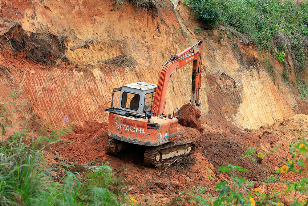 Cách đó vài thêm một chiếc máy múc cũng đang hoạt động hết công suất để san gạt đất lâm nghiệp
