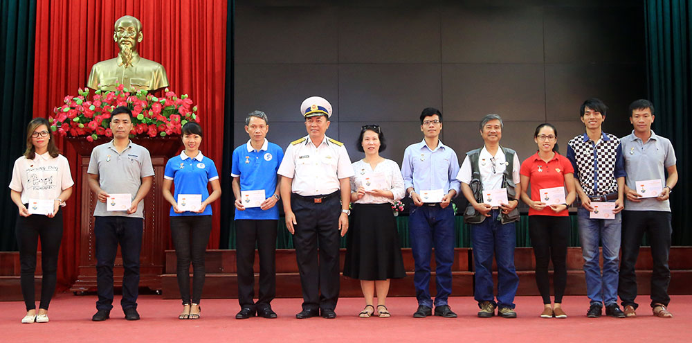Đại tá Nguyễn Công Sơn, Phó chính ủy Bộ tư lệnh Hải quân cùng 4 tặng huy hiệu “Chiến sĩ Trường Sa” cho các phóng viên báo, đài trung ương và địa phương tham gia chuyến công tác