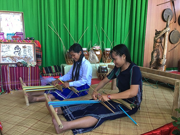 Học sinh dân tộc biểu diễn dệt thổ cẩm tại gian hàng trường mình