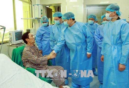 Bộ trưởng Bộ Quốc phòng Ngô Xuân Lịch thăm hỏi, chúc mừng bệnh nhân Trần Ngọc Hanh (54 tuổi, ở Nam Ðịnh) được ghép phổi lấy từ người cho chết não đầu tiên ở Việt Nam. Ảnh: An Đăng/TTXVN