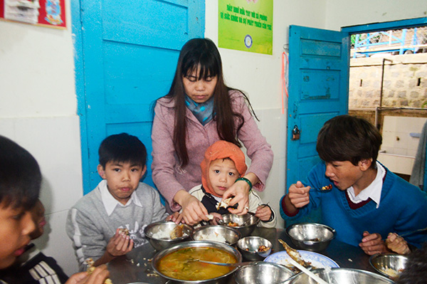 Bảo mẫu ở Trường Khiếm thính Lâm Đồng chăm chút từng miếng ăn cho học sinh khuyết tật. Ảnh: V.H