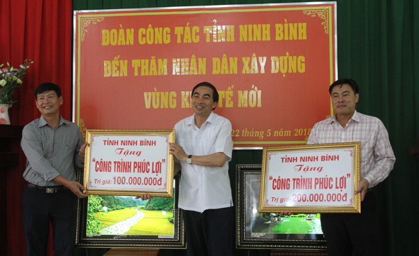 Ông Đinh Văn Điến, Chủ tịch UBND tỉnh Ninh Bình trao tiền tượng trưng cho xã Gia Viễn và Tiên Hoàng để sửa chữa, nâng cấp nhà văn hóa