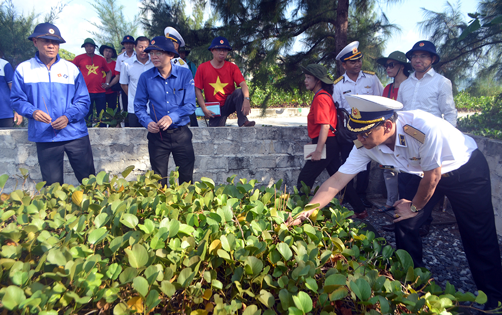 Chuần Đô đốc Ngô Sĩ Quyết và các thành viên trong đoàn công tác thắp hương trên phần mộ liệt sĩ trên đảo Sinh Tồn Đông