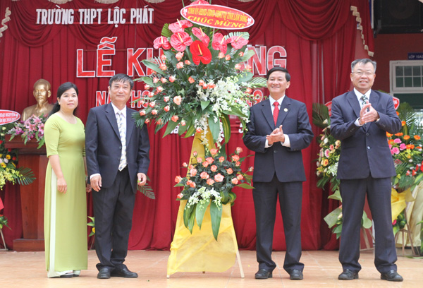 Đồng chí Trần Đức Quân, Phó Bí thư Tỉnh ủy, Chủ tịch HĐND tỉnh, trao lẳng hoa chúc mừng của Tỉnh ủy, HĐND, UBND, UBMTTQ tỉnh Lâm Đồng cho Trường THPT Lộc Phát (Bảo Lộc). Ảnh: Đông Anh