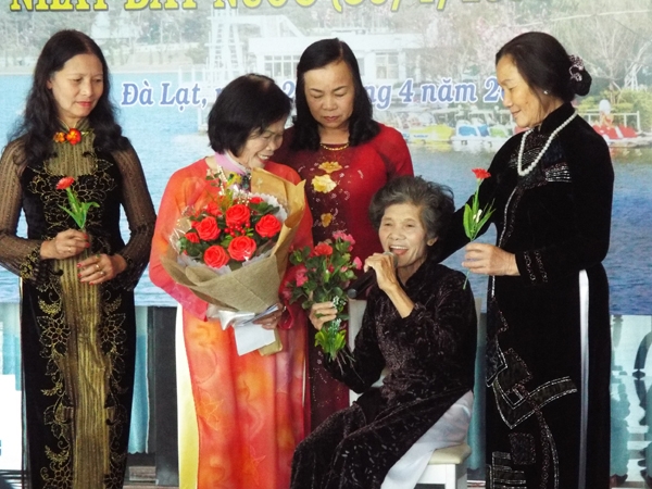 Tặng hoa cho tiết mục ngâm thơ xuất sắc của cây bút cao tuổi Lê Thị Đỉnh (người ngồi)