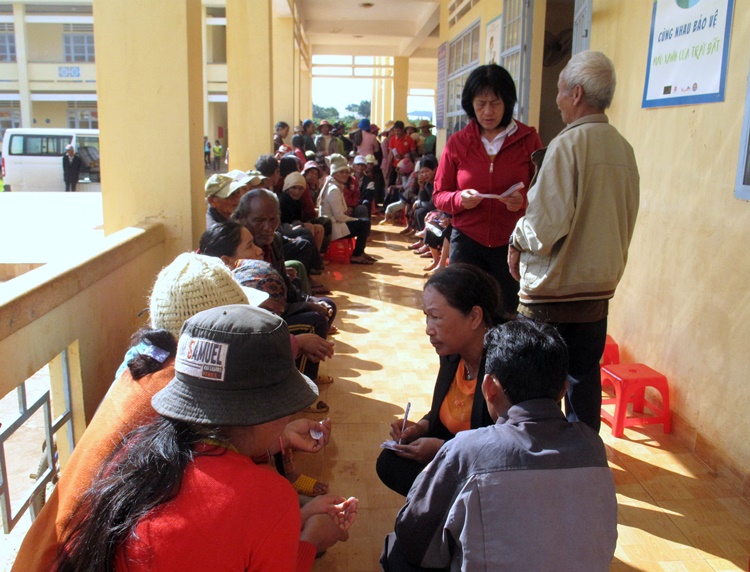 Cô Nga - nhân viên y tế thôn bản Buôn Chuối (đang cầm bút) phát số thứ tự cho bà con DTTS trong đợt khám bệnh từ thiện. Ảnh: A.Nhiên