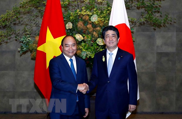 Thủ tướng Nhật Bản Abe Shinzo đón Thủ tướng Nguyễn Xuân Phúc đến dự Lễ trao đổi các văn kiện hợp tác. (Ảnh: Thống Nhất/TTXVN)