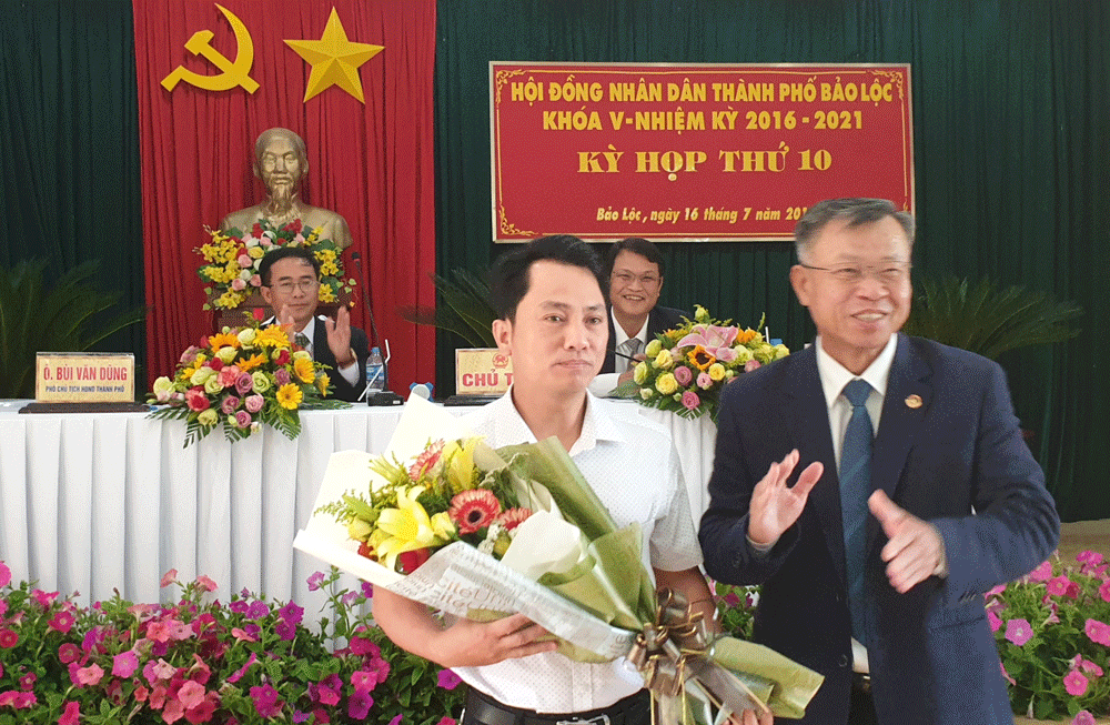 Ông Nguyễn Quốc Bắc, Chủ tịch UBND thành phố Bảo Lộc tặng hoa chúc mừng ông Hoàng Việt Phương được bầu ủy viên UBND thành phố Bảo Lộc