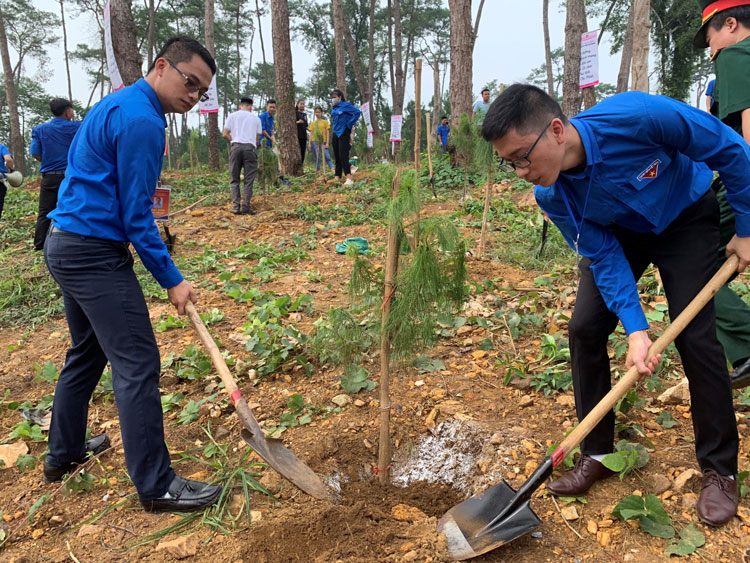 Anh Vũ Thành Công (phải) và anh Trần Thanh Cảnh (trái) tham gia trồng cây lưu niệm tại Khu Di tích Chủ tịch Hồ Chí Minh