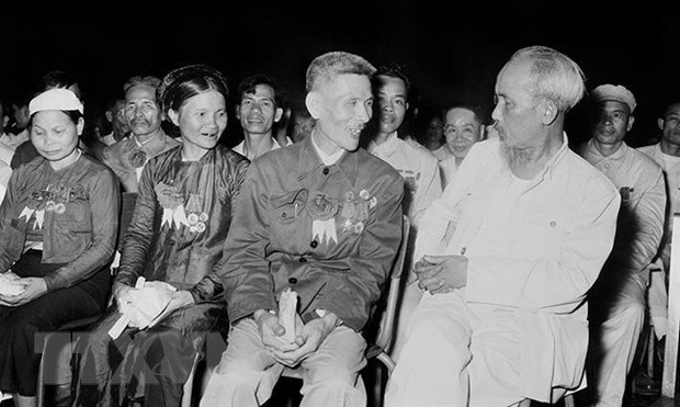Chủ tịch Hồ Chí Minh nói chuyện thân mật với Anh hùng Lao động Nguyễn Phúc Đồng (ngành Quân giới) và nữ anh hùng Nguyễn Thị Năm (dệt Nam Định) trong buổi họp mặt các đại biểu dự Đại hội liên hoan Anh hùng, Chiến sỹ thi đua Công-Nông-Binh toàn quốc lần thứ II tại Hà Nội (7/7/1958).