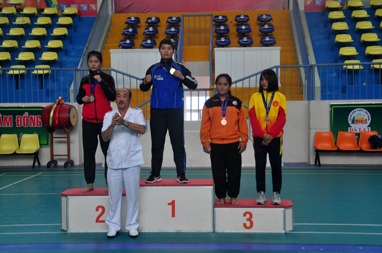 VĐV Lương Thị Tuyết Vân (giữa, trên bục) của đoàn Lâm Đồng nhận HC vàng nội dung đối kháng nữ 70 kg 