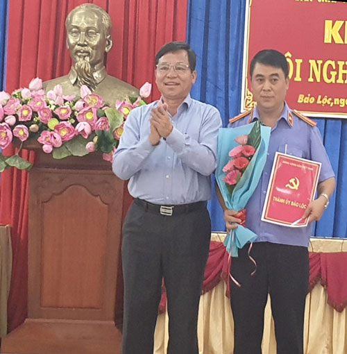 Ông Nguyễn Văn Triệu, Ủy viên Ban Thường vụ Tỉnh ủy, Bí thư Thành ủy Bảo Lộc, tặng hoa chúc mừng ông Đặng Văn Đông - Viện trưởng Viện kiểm sát nhân dân thành phố Bảo Lộc, được Ban Thường vụ Tỉnh ủy chỉ định ủy viên Ban chấp hành Đảng bộ TP Bảo Lộc khóa V