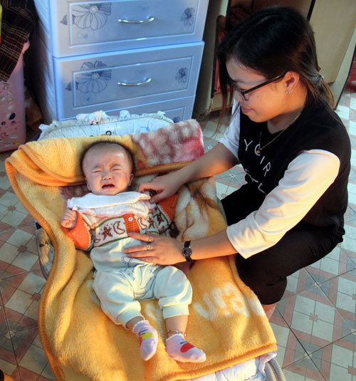 Điều dưỡng - bảo mẫu Trâm đang chăm sóc bé khuyết tật đặc biệt nặng do bị ung thư não.