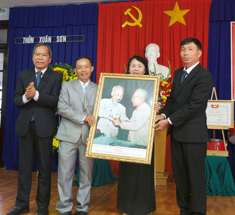 Ông Nguyễn Xuân Tiến - Ủy viên Ban Chấp hành Trung ương Đảng, Bí thư Tỉnh ủy Lâm Đồng trao tặng bức ảnh Bác Hồ và Bác Tôn cho đại diện thôn Xuân Sơn. Ảnh: Nguyễn Nghĩa