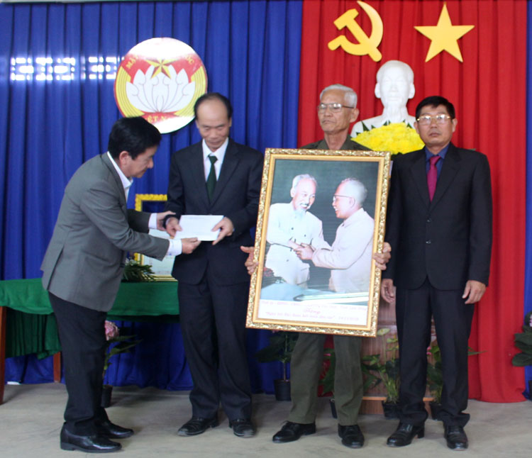 Đồng chí Phó Chủ tịch UBND tỉnh Lâm Đồng Phan Văn Đa trao tặng chính quyền và Nhân dân thôn Thanh Bình 3 (xã Hiệp Thạnh, huyện Đức Trọng) bức ảnh “Bác Hồ và Bác Tôn” cùng phần quà của tỉnh. Ảnh: T.VŨ