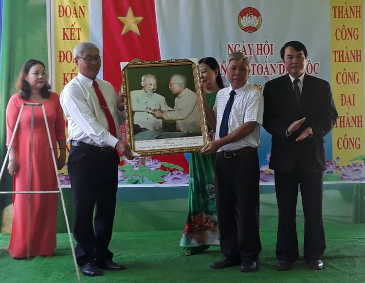 Thay mặt lãnh đạo tỉnh, ông Phạm S đã tặng cán bộ, nhân dân Thôn 3 bức ảnh Bác Hồ và Bác Tôn. Ảnh: Trịnh Chu