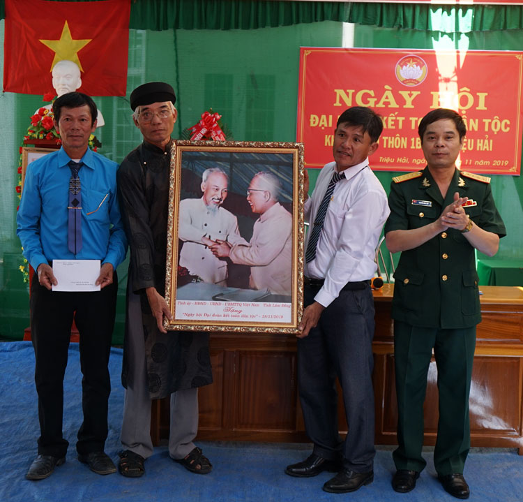 Đồng chí Nguyễn Bình Sơn, Chỉ huy trưởng Ban Chỉ huy Quân sự tỉnh Lâm Đồng, trao tặng bức ảnh “Bác Hồ và Bác Tôn” và số tiền 10 triệu đồng cho cán bộ, nhân dân Thôn 1B (xã Triệu Hải, huyện Đạ Tẻh). Ảnh: Phạm Công Tám