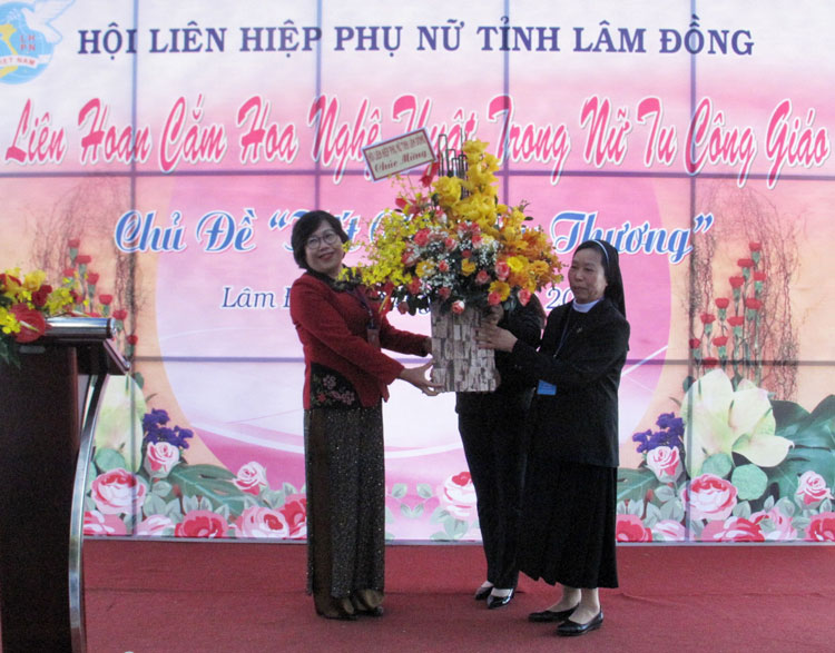 Bà Phạm Thị Mỹ Huyền - Chủ tịch Hội LHPN tỉnh tặng hoa chúc mừng Giáng sinh cho Soeur Đỗ Thị Ninh - Ủy viên Ban Chấp hành Hội LHPN tỉnh, thành viên Ban tổ chức và Ban giám khảo Liên hoan
