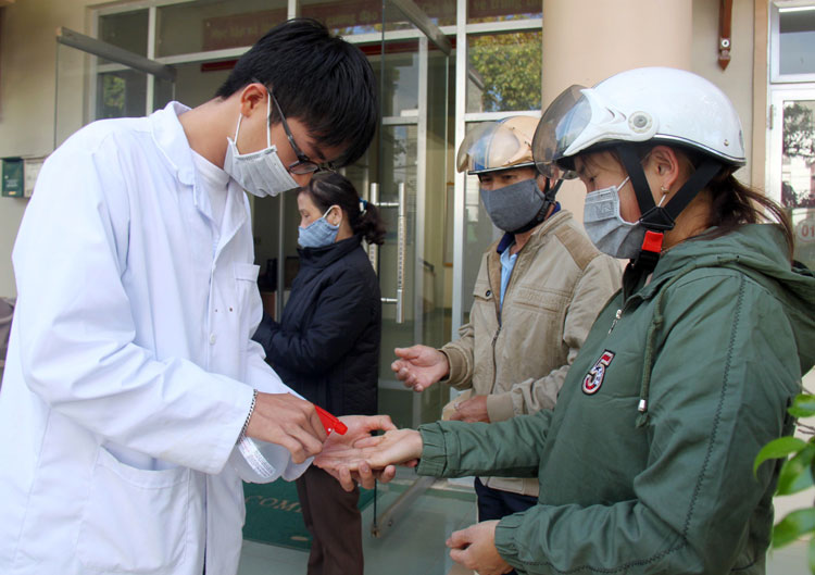 Hướng dẫn và xịt dung dịch sát khuẩn cho người dân đến liên hệ công việc tại các đơn vị hành chính