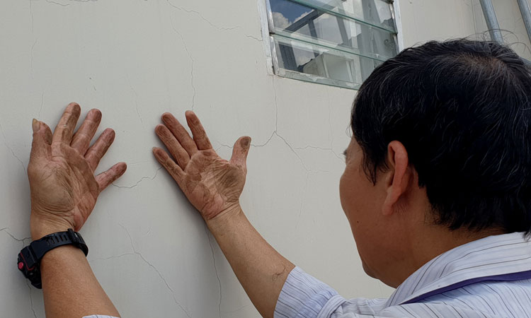 Chỉ xoa nhẹ vào tường nhà, bàn tay ông Bùi Văn Tứ bám đầy bụi