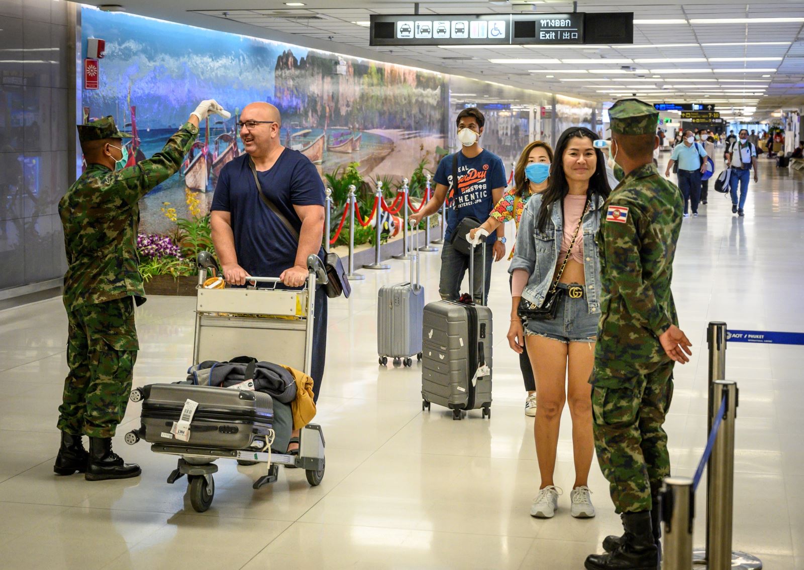Trong ảnh: Binh sĩ Thái Lan kiểm tra thân nhiệt hành khách tại sân bay quốc tế Phuket nhằm ngăn chặn sự lây lan của dịch COVID-19, ngày 19/3/2020