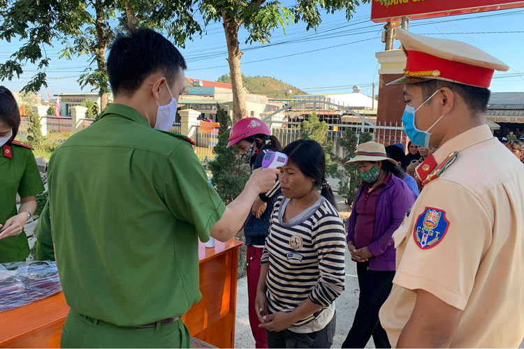 Thanh niên Công an huyện Di Linh đo thân nhiệt cho người dân
