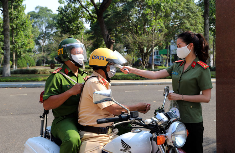 Công an TP Bảo Lộc đo thân nhiệt và sát khuẩn tay cho cán bộ, chiến sĩ. Ảnh: Khánh Phúc