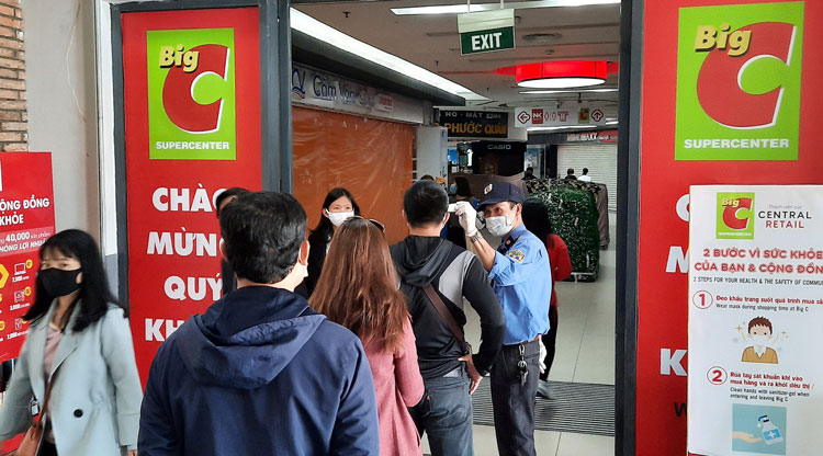 Siêu thị Big C vẫn mở cửa phục vụ các mặt hàng nhu yếu phẩm, khách hàng xếp hàng kiểm tra thân nhiệt trước khi vào. Ảnh: Minh Đạo