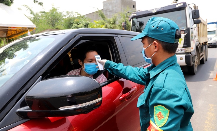 Với lượng phương tiện qua lại lớn, đặc biệt là trong các giờ cao điểm, chốt số 1 luôn có 4 người (3 nhân viên y tế và 1 dân quân) được giao nhiệm vụ kiểm tra thân nhiệt tại 2 làn lưu thông xe máy và ô tô. Tùy vào tình hình, lực lượng kiểm tra thân nhiệt tự linh động cùng phối hợp phân chia và hỗ trợ nhau làm nhiệm vụ. Ảnh: K.P