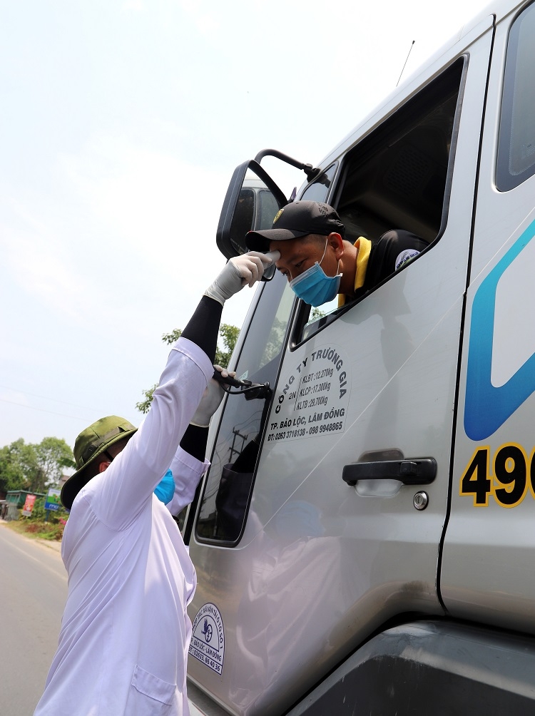 Mỗi công việc của những người làm nhiệm vụ tại các chốt kiểm dịch đều có những vất vả và tiềm ẩn rủi ro, nguy hiểm riêng. Thế nhưng, có lẽ nhiệm vụ kiểm tra y tế (đo thân nhiệt) luôn là nhiệm vụ nặng nề và tiềm ẩn nguy hiểm hơn cả. Ngoài việc thường xuyên đối diện trực tiếp với người lạ, lực lượng kiểm tra y tế còn liên tục rướn người hết cỡ hoặc thậm chí phải leo trèo khi đo thân nhiệt cho tài xê xe đầu kéo và xe tải hạng nặng có cabin cao lớn (Ảnh – K.P)