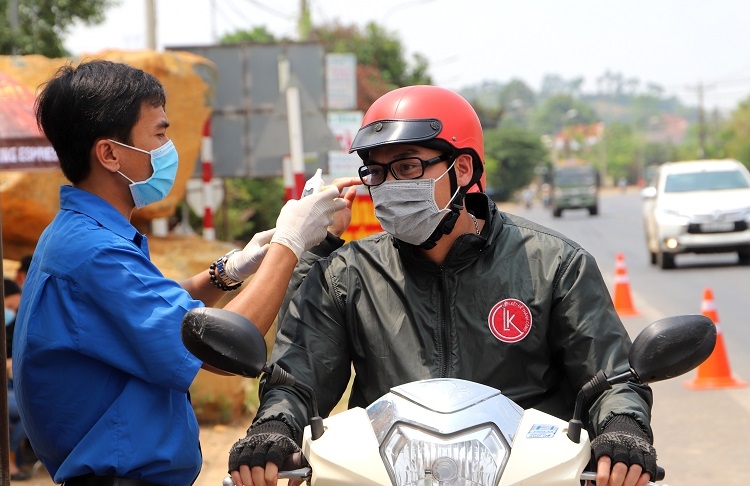 Thanh niên tình nguyện tham gia “chia lửa” làm nhiệm vụ đo thân nhiệt người điểu khiển xe máy tại chốt kiểm dịch Quốc lộ 20 trong các giờ cao điểm phương tiện giao thông qua lại đông đúc đã phần nào giúp các lực lượng tuyến đầu làm nhiệm vụ tại chốt giảm bớt áp lực, hoàn thành tốt nhiệm vụ (Ảnh – K.P)