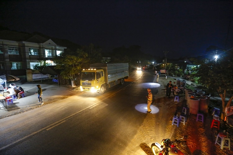 Phía ngoài lều dã chiến để khai báo y tế, lực lượng cảnh sát giao thông, cảnh sát cơ động liên tục dùng đèn pin ra hiệu lệnh các xe tải dừng đỗ đúng vị trí, phân luồng tránh tình trạng ùn ứ cục bộ. Trong ngày 10/4, theo ghi nhận có khoảng 5-6 người dân đi xe máy không chấp hành hiệu lệnh, lực lượng cảnh sát giao thông đã phải dùng xe chuyên dụng đuổi theo, yêu cầu người dân quay lại khai báo y tế tại chốt trực. Ảnh: C.T