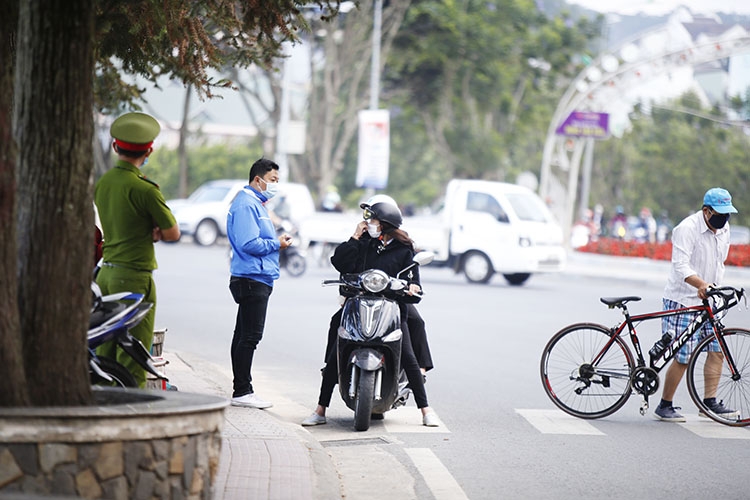 Lực lượng Công an, dân quân tự vệ, thanh niên tình nguyện vẫn chốt trực tại các địa điểm công cộng đông người qua lại tại khu trung tâm TP Đà Lạt để nhắc nhở người dân đeo khẩu trang, không tụ tập đông người. Nhờ kiểm tra, nhắc nhở liên tục nên một số người dân đã thực hiện nghiêm túc hơn